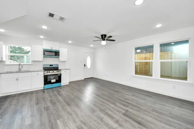 a kitchen with stainless steel appliances white cabinets and a stove top oven