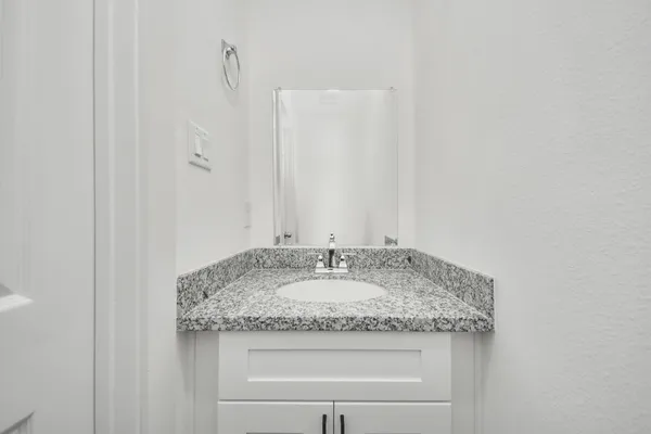 a bathroom with a granite countertop sink and a mirror