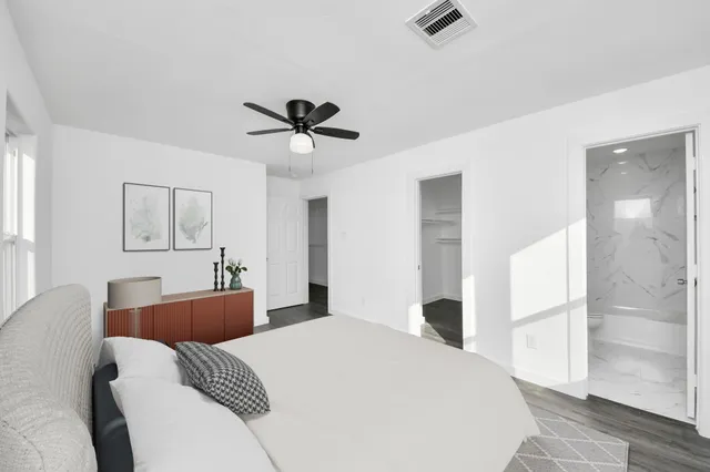 a bedroom with a large bed and a chandelier