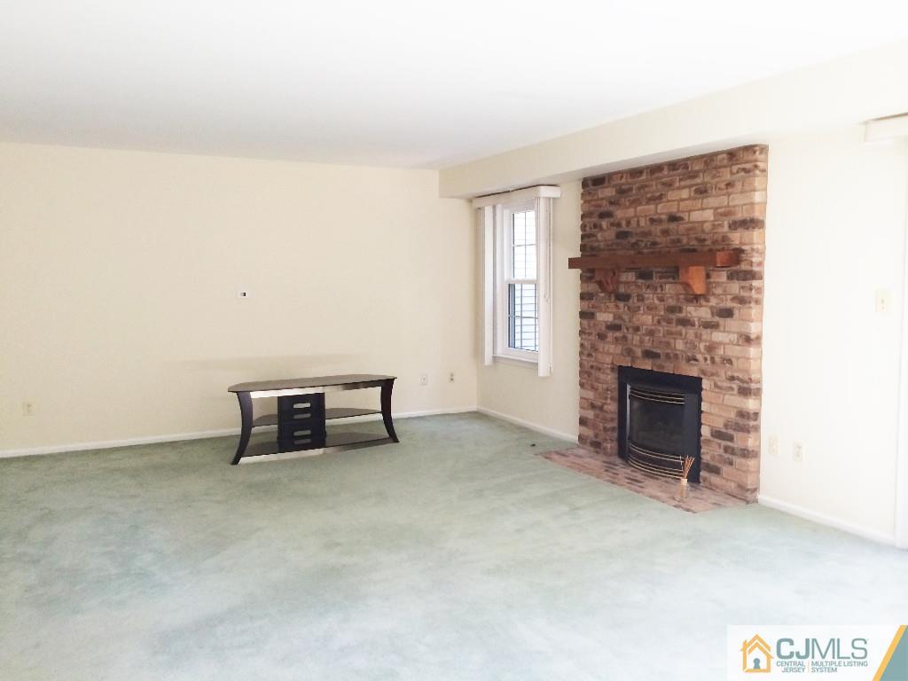 4607 Stonehedge Road Edison, NJ 08820 - Photo 5 of 10 an empty room with furniture and fireplace