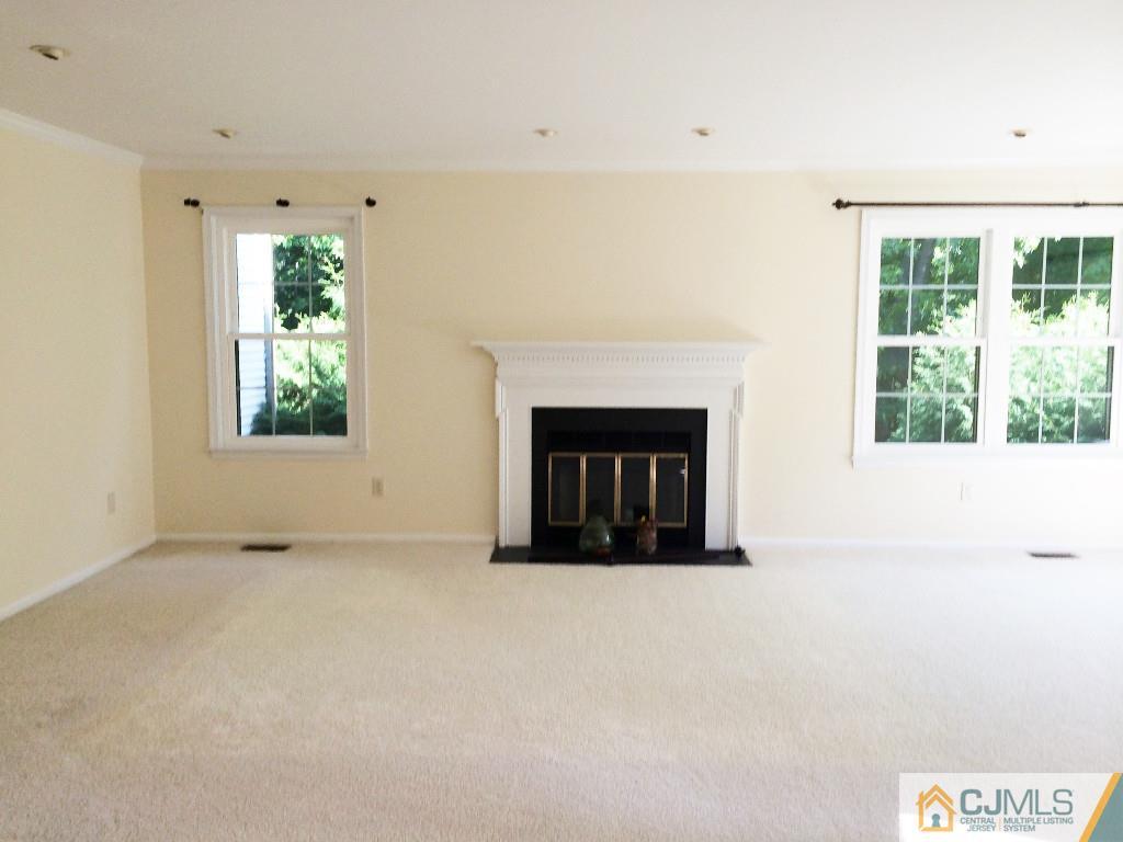 4607 Stonehedge Road Edison, NJ 08820 - Photo 6 of 10 an empty room with windows and fireplace