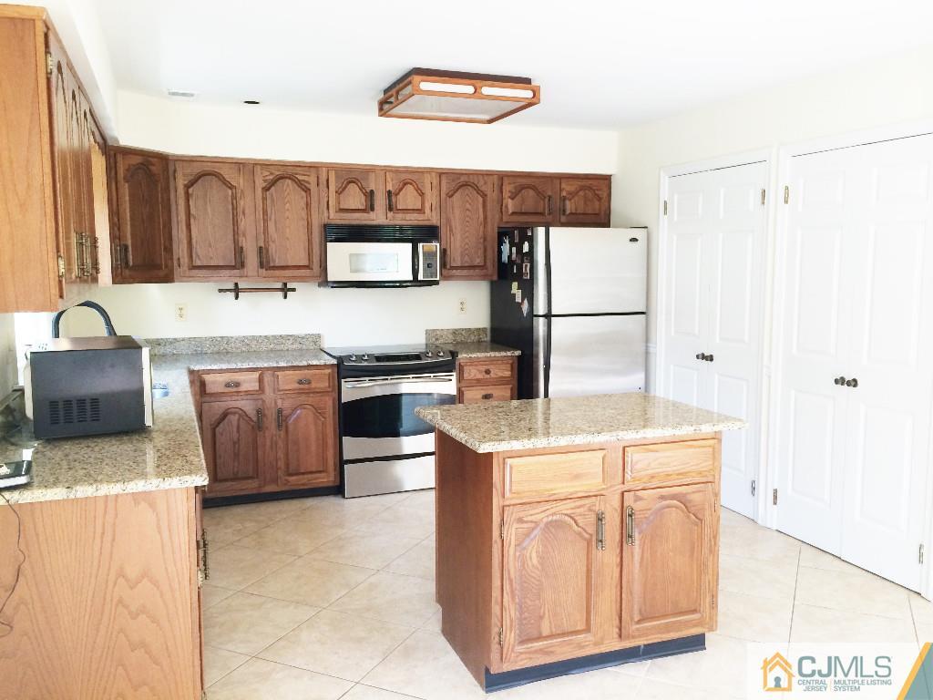 4607 Stonehedge Road Edison, NJ 08820 - Photo 7 of 10 a kitchen with a stove a refrigerator and a sink