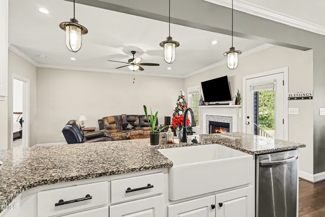 a kitchen with stainless steel appliances kitchen island granite countertop a stove and white cabinets