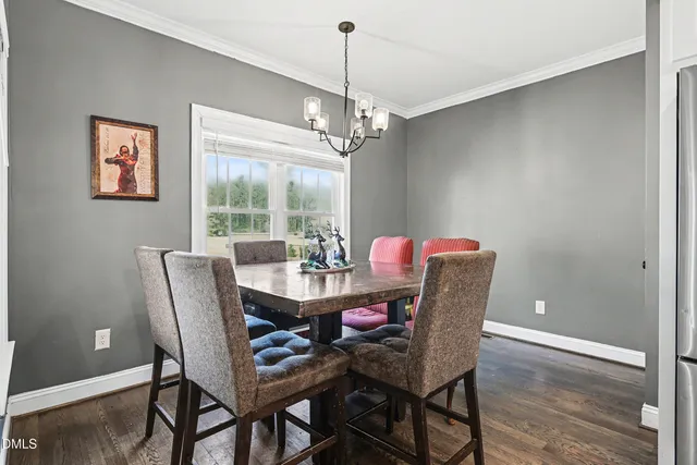 a dining room with furniture a chandelier and window