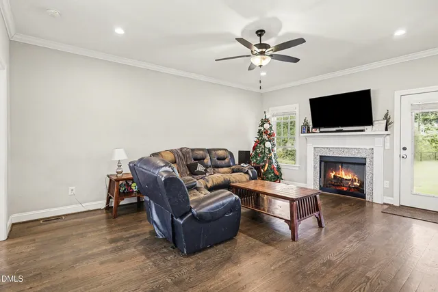 a living room with furniture a fireplace and a flat screen tv