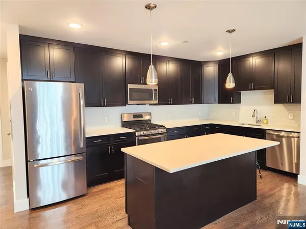 a kitchen with stainless steel appliances granite countertop a refrigerator a sink and a stove