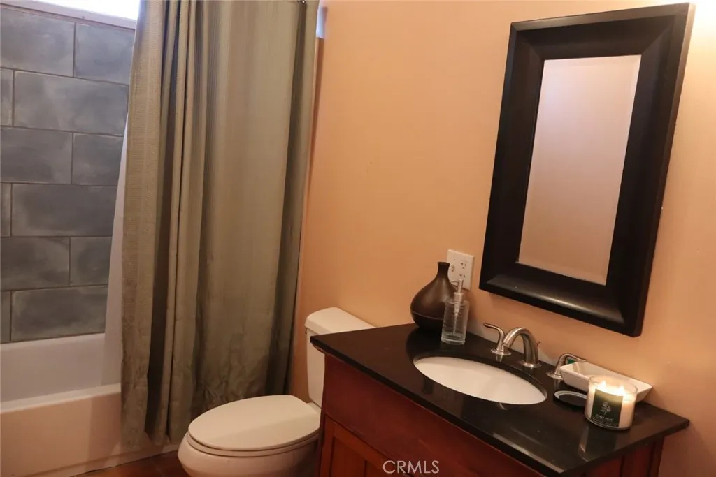 15325 Orange, Unit F16 Paramount, CA 90723 - Photo 19 of 25 a bathroom with a sink a toilet a mirror and shower