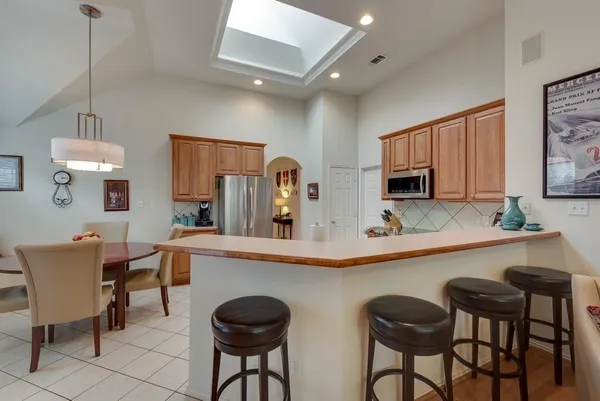 a kitchen with stainless steel appliances granite countertop table chairs sink and cabinets