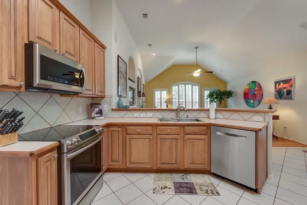 a kitchen with stainless steel appliances granite countertop a stove a sink and a microwave