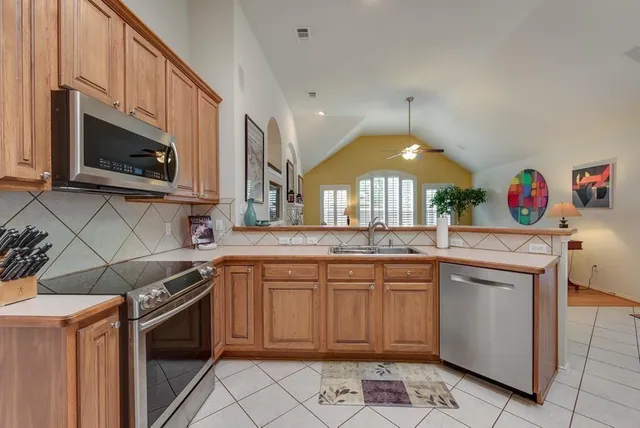 a kitchen with stainless steel appliances granite countertop a stove a sink and a microwave