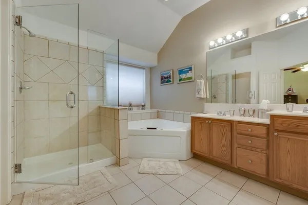 a spacious bathroom with a shower a sink and mirror