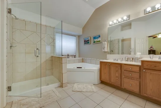a spacious bathroom with a shower a sink and mirror