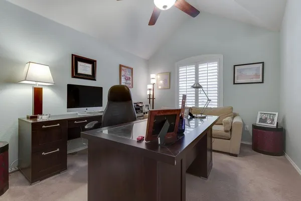 a view of a workspace with furniture and a window