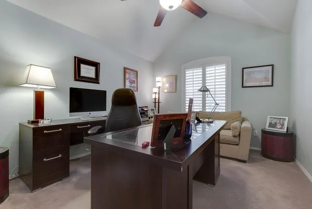 a view of a workspace with furniture and a window