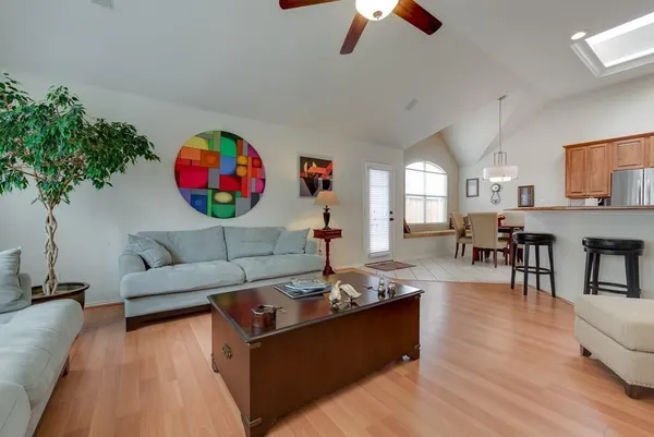 a living room with furniture kitchen view and a chandelier