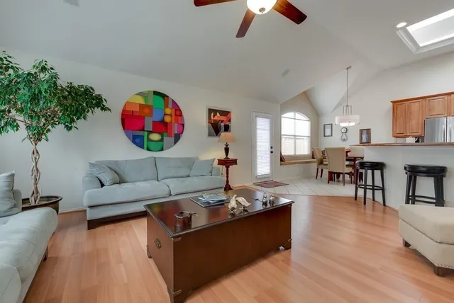 a living room with furniture kitchen view and a chandelier