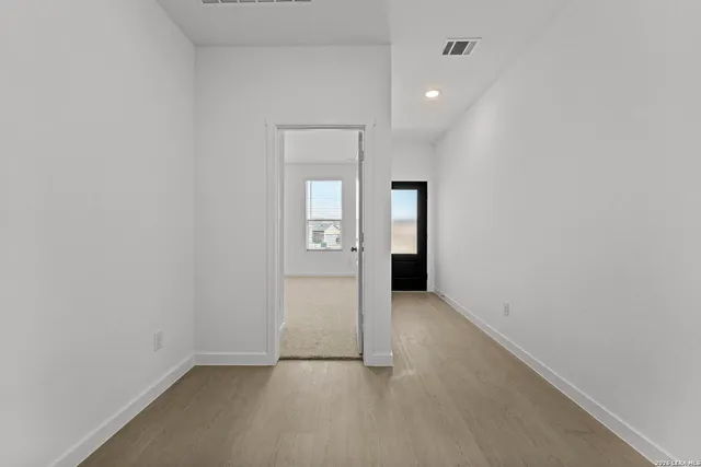 a view of a hallway with closet and a bathroom