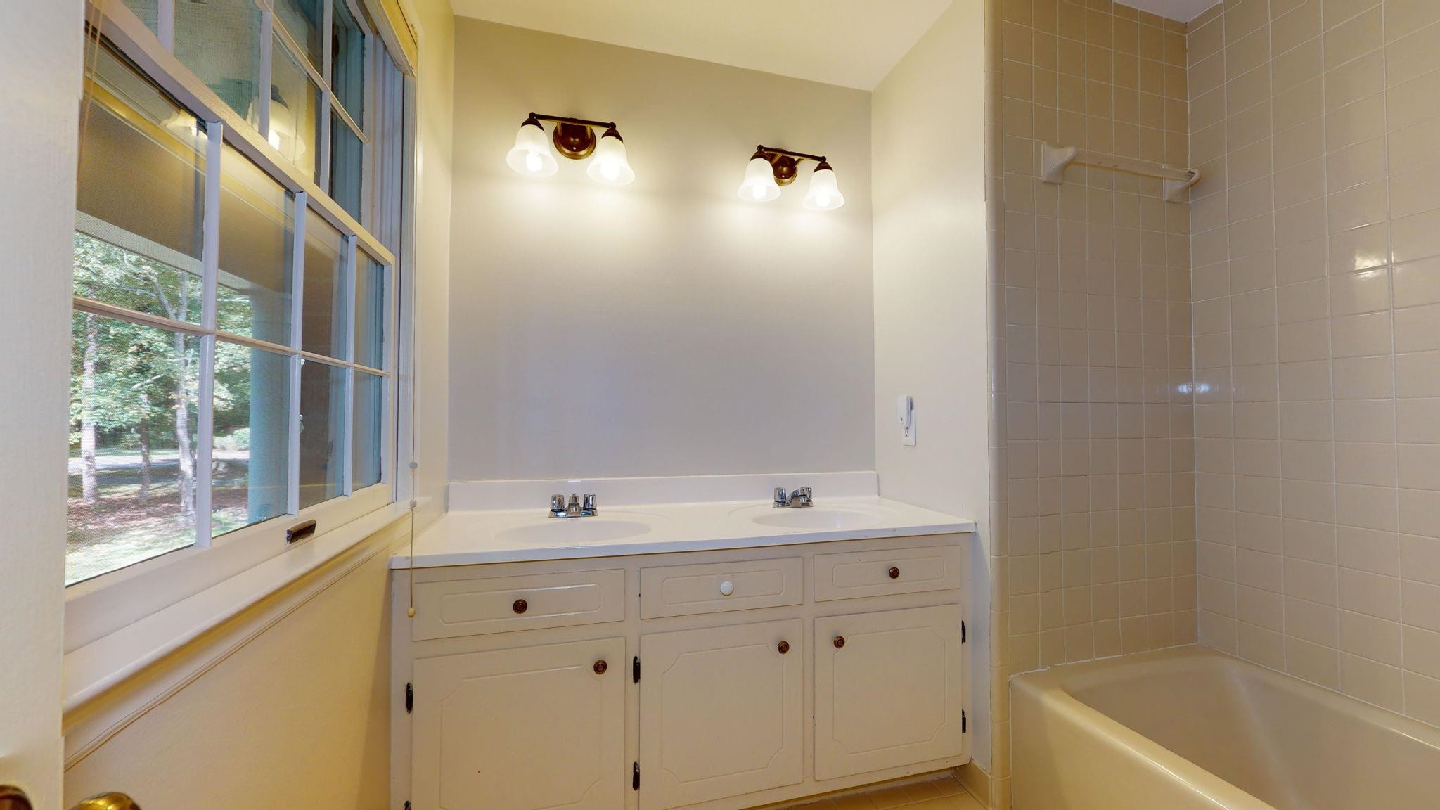 5308 Craig Road Durham, NC 27712 - Photo 45 of 46 a bathroom with a sink double vanity mirror and a bathtub