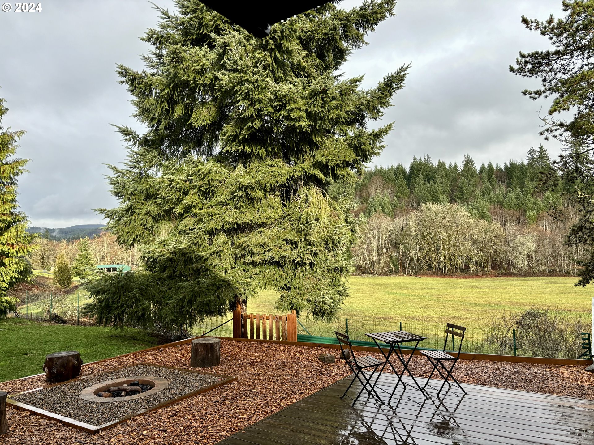 23300 Northwest Bravo Road Buxton, OR 97109 - Photo 32 of 47 a view of a lake with couches and wooden fence
