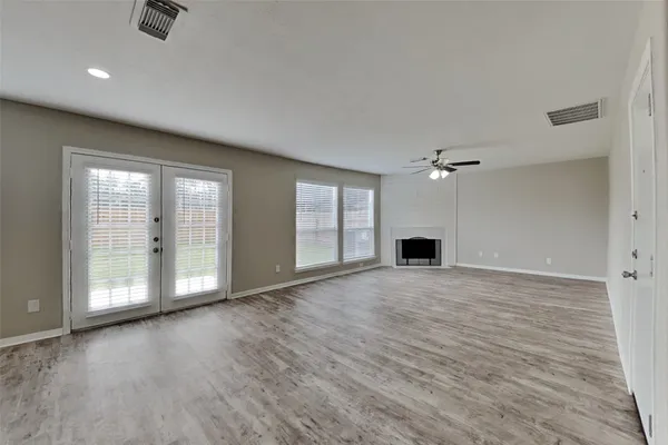 a view of an empty room with a fireplace and a window