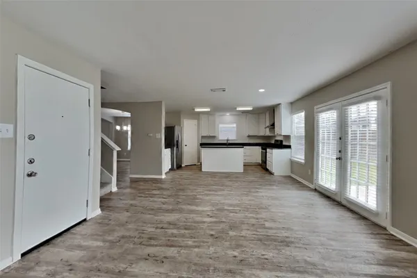 a large white kitchen with a refrigerator and a sink