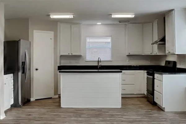 a kitchen with granite countertop a sink and a stove