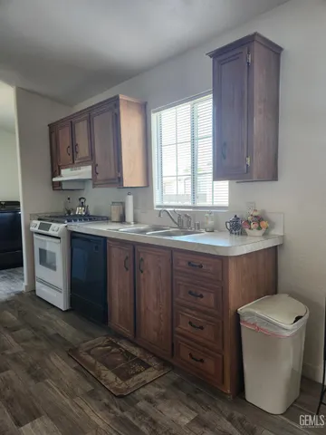 a kitchen with a sink a stove and cabinets