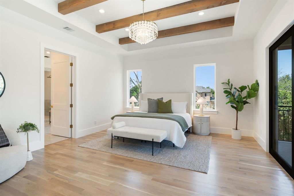 6437 Churchill Way Dallas, TX 75230 - Photo 19 of 38 a spacious bedroom with a bed and a potted plant