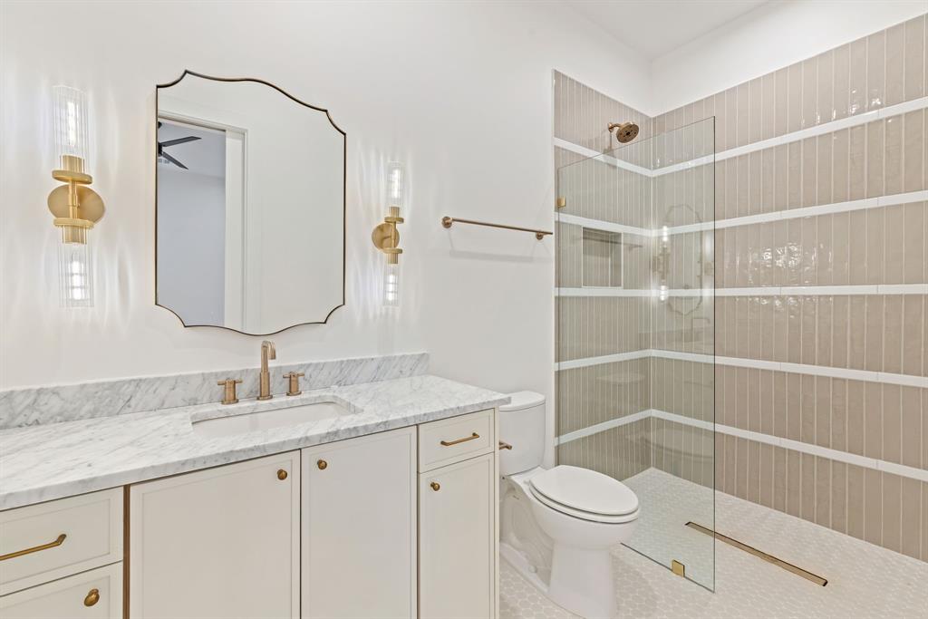 6437 Churchill Way Dallas, TX 75230 - Photo 24 of 38 a bathroom with a sink a toilet and shower