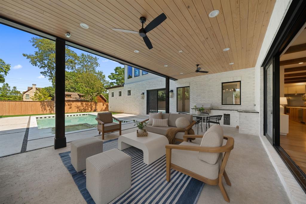 6437 Churchill Way Dallas, TX 75230 - Photo 32 of 38 a living room with patio furniture and a floor to ceiling window