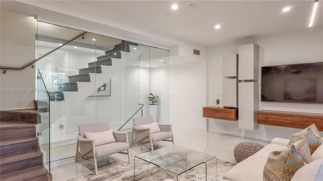 a living room with furniture a flat screen tv and kitchen view
