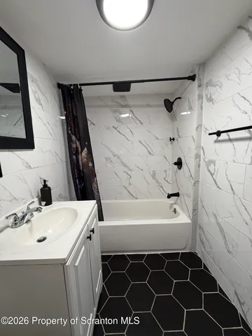 a spacious bedroom with a bed and a chandelier