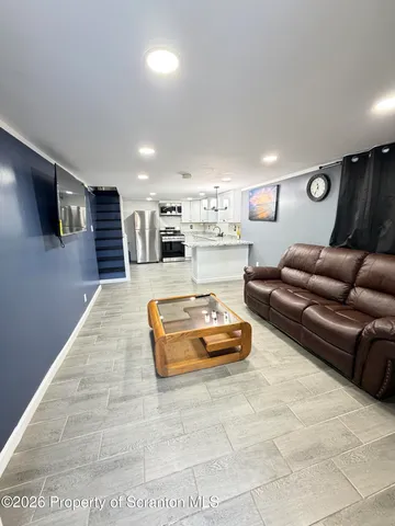 a kitchen with kitchen island granite countertop a sink a counter top space cabinets and stainless steel appliances