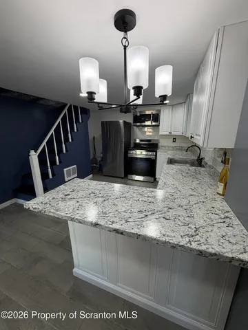 a large kitchen with stainless steel appliances granite countertop a stove a sink dishwasher and a refrigerator