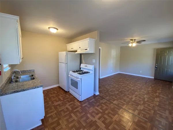 a kitchen with granite countertop a sink and cabinets