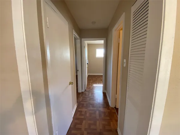 a view of a hallway with a wooden door