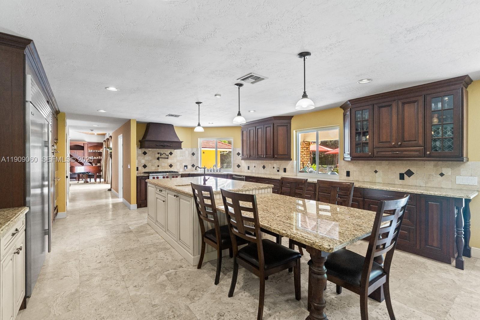 6500 Southwest 127th Street Pinecrest, FL 33156 - Photo 16 of 68 a large kitchen with a table and chairs