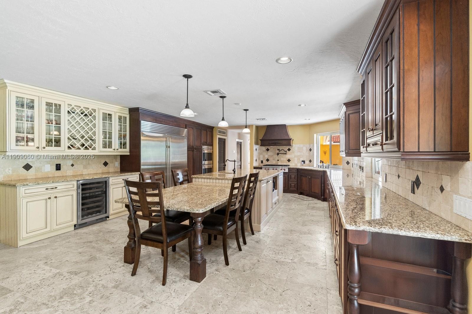6500 Southwest 127th Street Pinecrest, FL 33156 - Photo 18 of 68 a large kitchen with a table and chairs