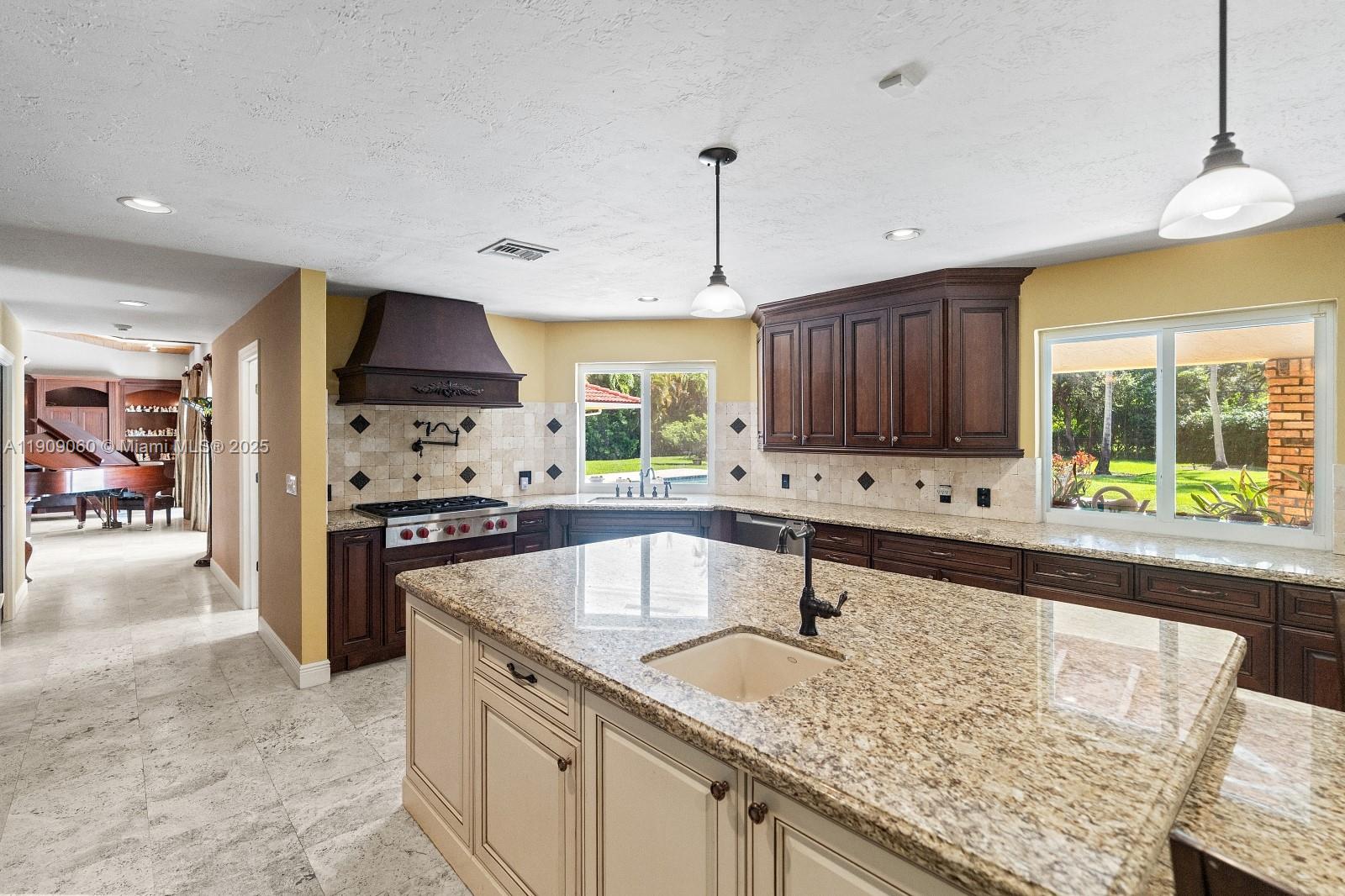 6500 Southwest 127th Street Pinecrest, FL 33156 - Photo 23 of 68 a kitchen with stainless steel appliances granite countertop a sink a stove and a refrigerator