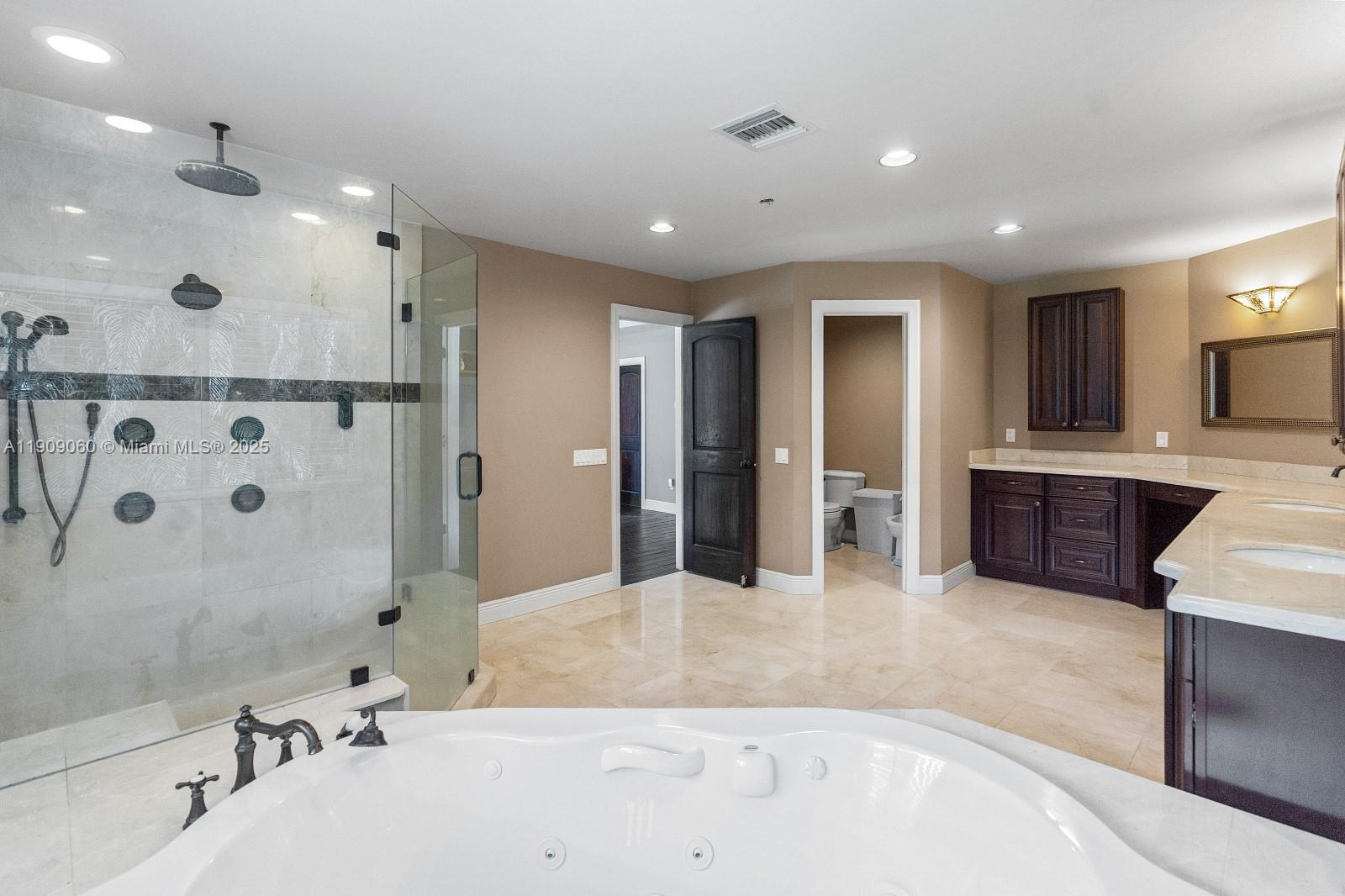 6500 Southwest 127th Street Pinecrest, FL 33156 - Photo 28 of 68 a spacious bathroom with a tub sink and mirror