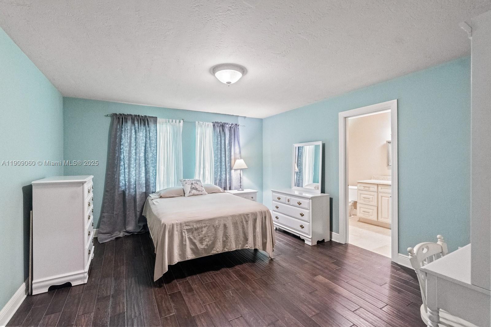 6500 Southwest 127th Street Pinecrest, FL 33156 - Photo 31 of 68 a bedroom with a bed and wooden floor