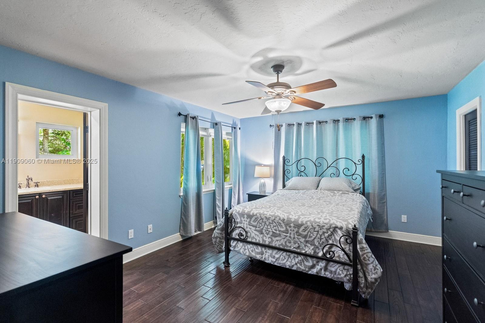 6500 Southwest 127th Street Pinecrest, FL 33156 - Photo 34 of 68 a bedroom with a large bed window and a ceiling fan