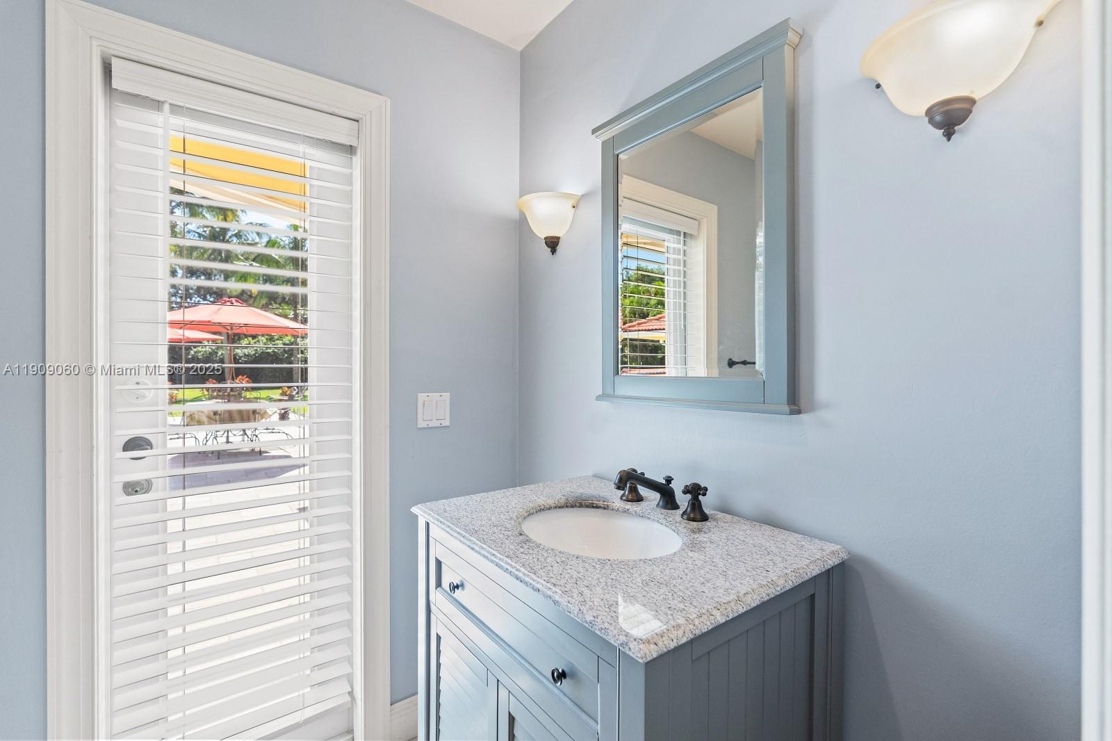 6500 Southwest 127th Street Pinecrest, FL 33156 - Photo 42 of 68 a bathroom with a granite countertop sink and a mirror