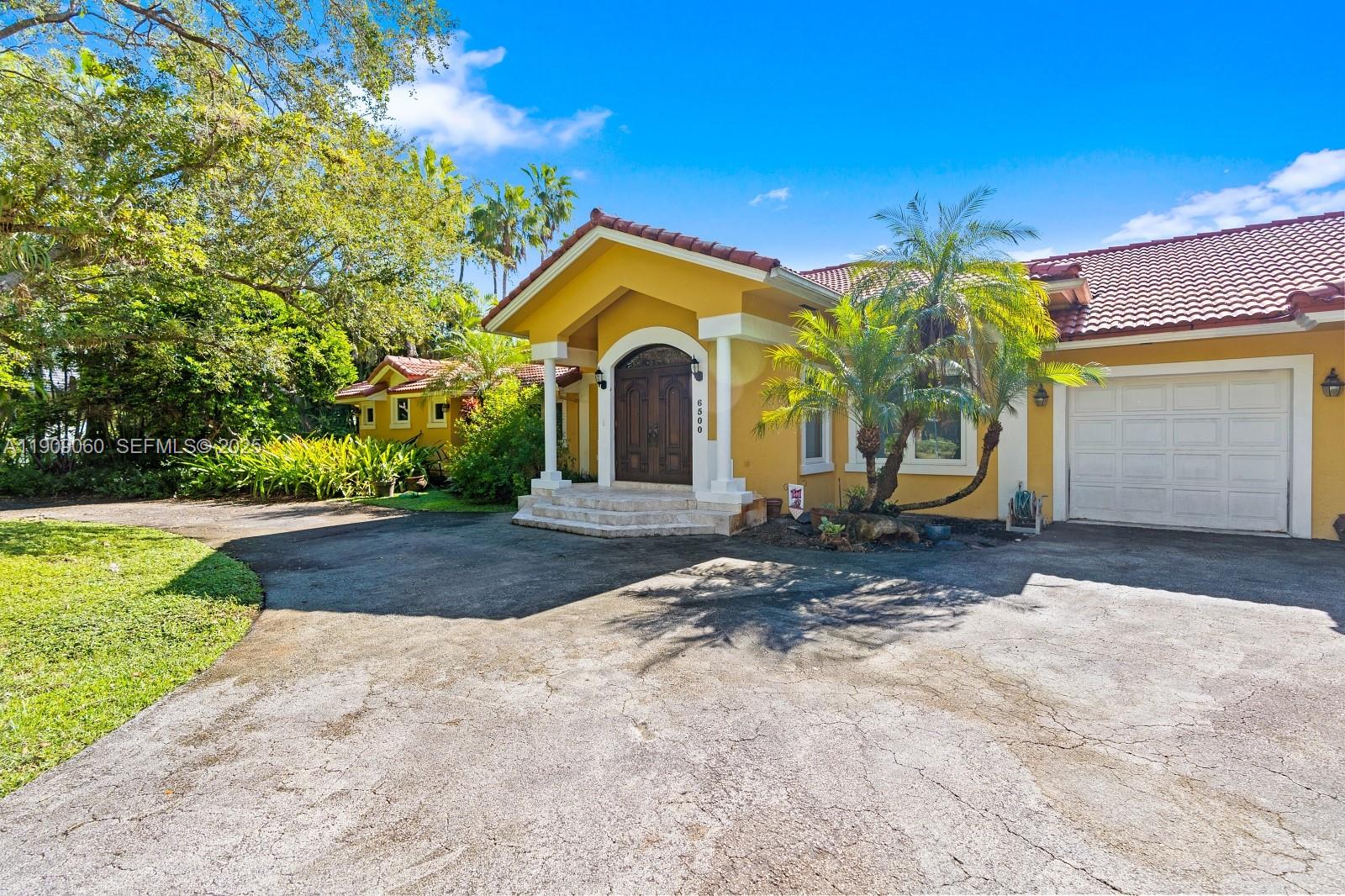 6500 Southwest 127th Street Pinecrest, FL 33156 - Photo 55 of 68 a front view of a house with garden