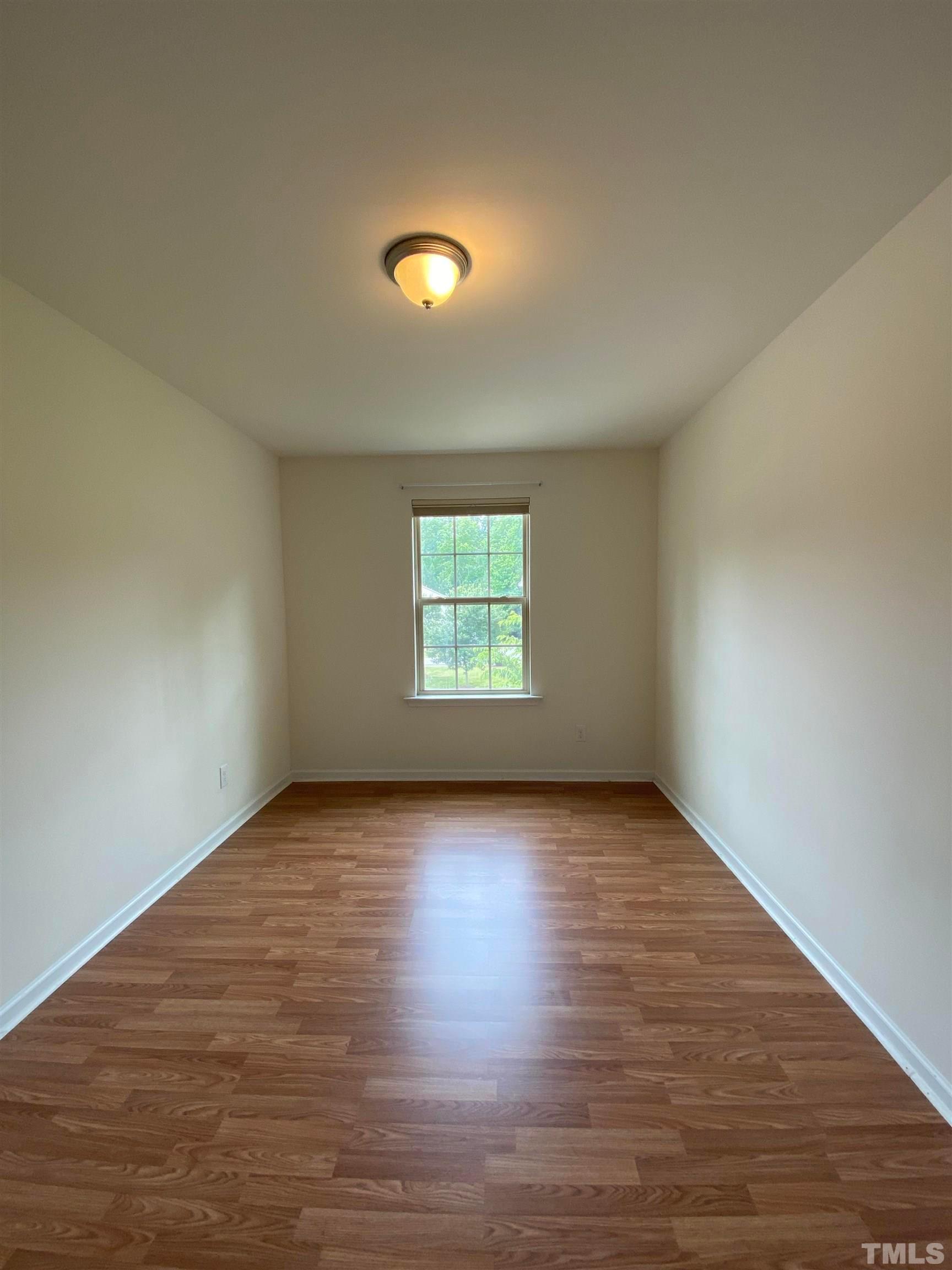 1458 Chatuga Way Wake Forest, NC 27587 - Photo 16 of 25 a view of an empty room with wooden floor and a window