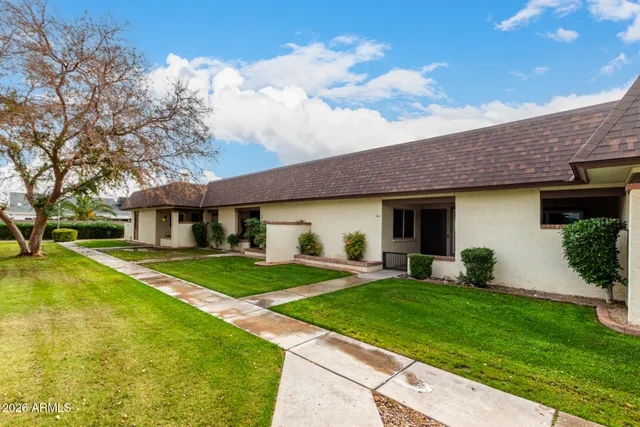 a front view of a house with a yard and trees