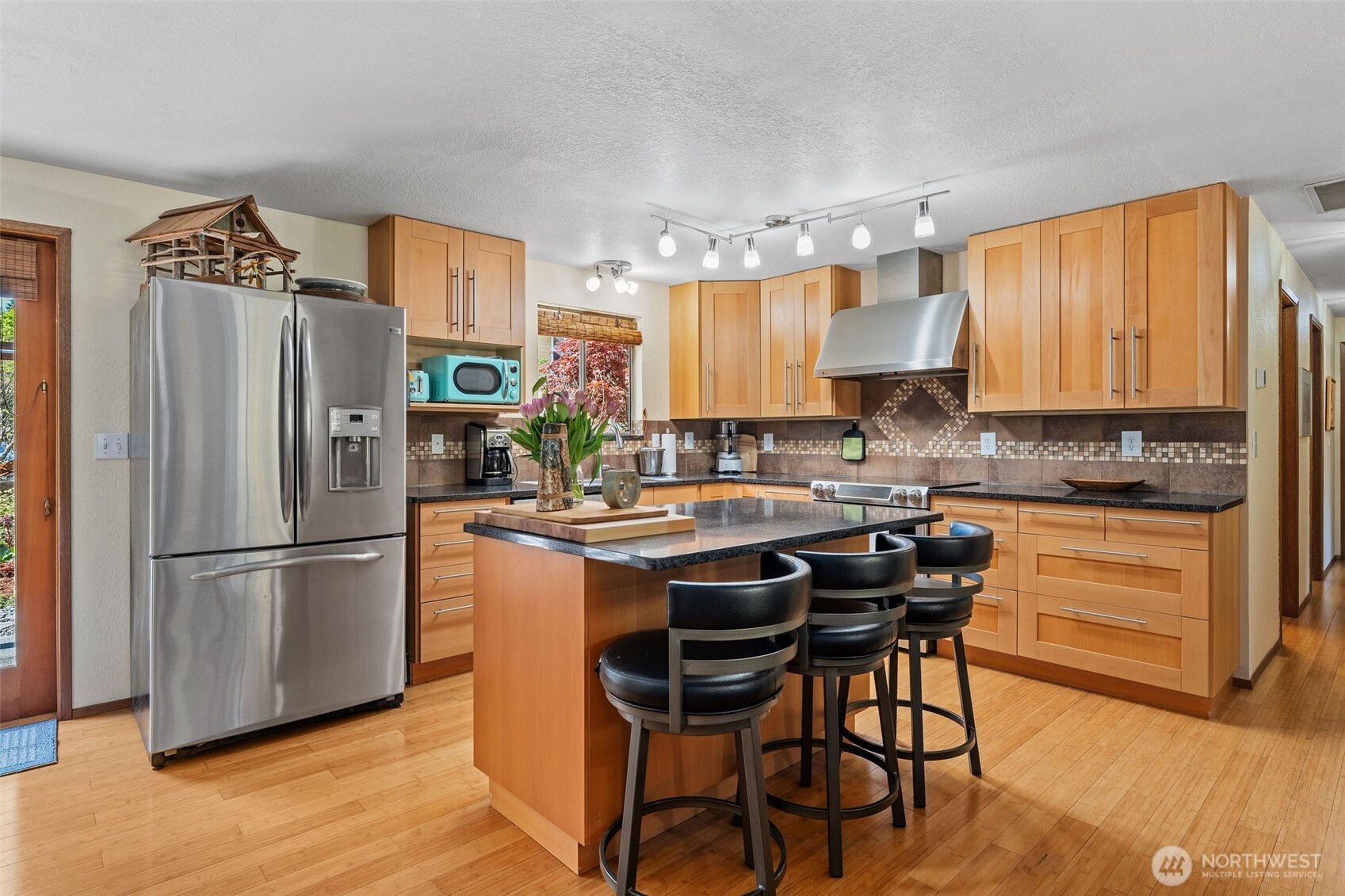 4405 Royal Court Carnation, WA 98014 - Photo 9 of 34 a kitchen with stainless steel appliances granite countertop a refrigerator a stove a sink dishwasher and white cabinets with wooden floor