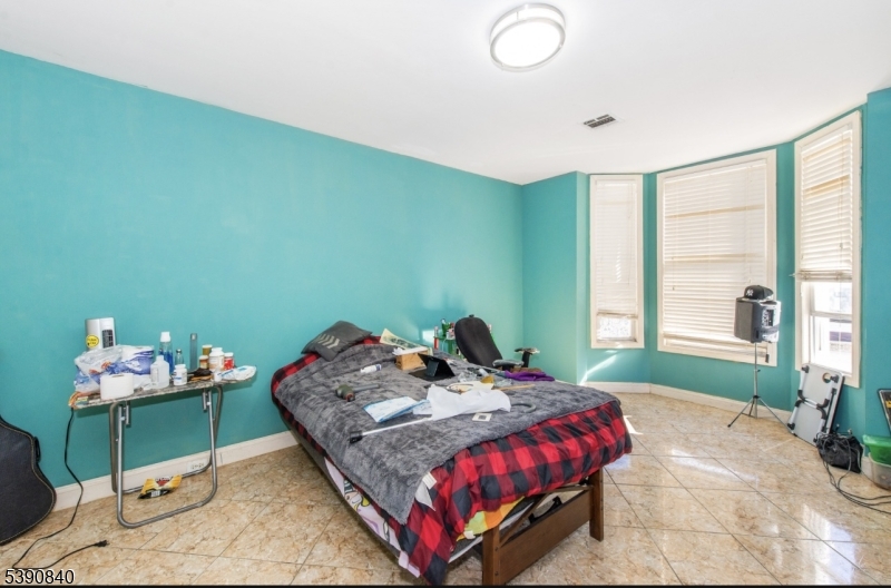 377-379 Ellison Street Paterson, NJ 07501 - Photo 25 of 28 a bedroom with a bed and a window