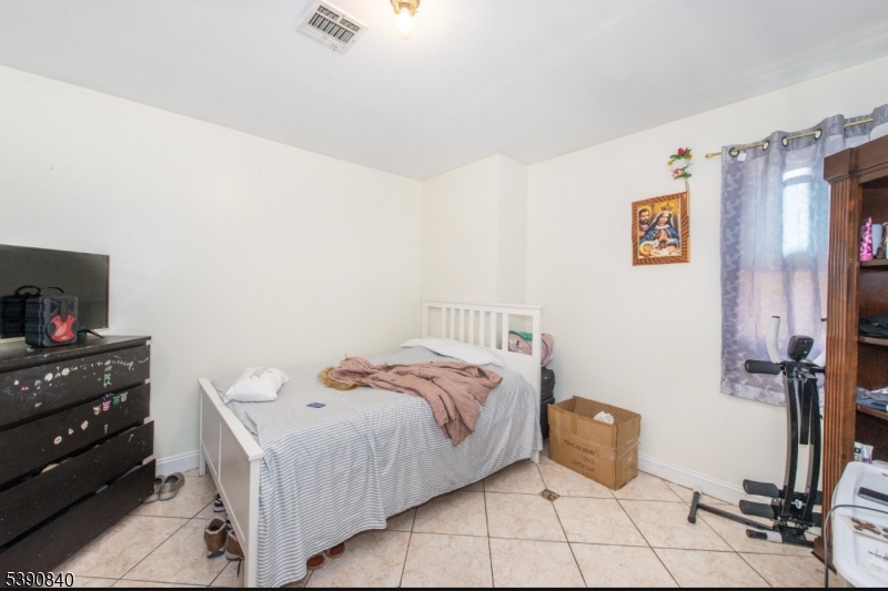 377-379 Ellison Street Paterson, NJ 07501 - Photo 4 of 28 a bed room with a bed and a television