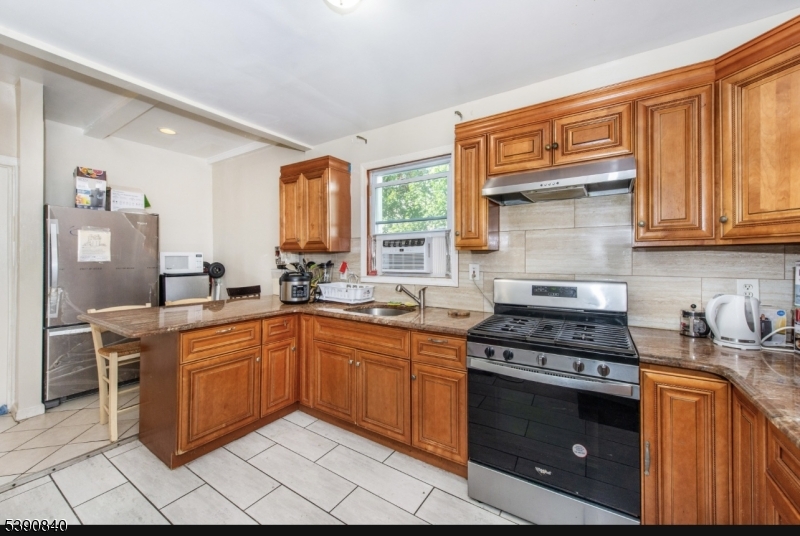 377-379 Ellison Street Paterson, NJ 07501 - Photo 8 of 28 a kitchen with stainless steel appliances granite countertop a stove a sink and a microwave